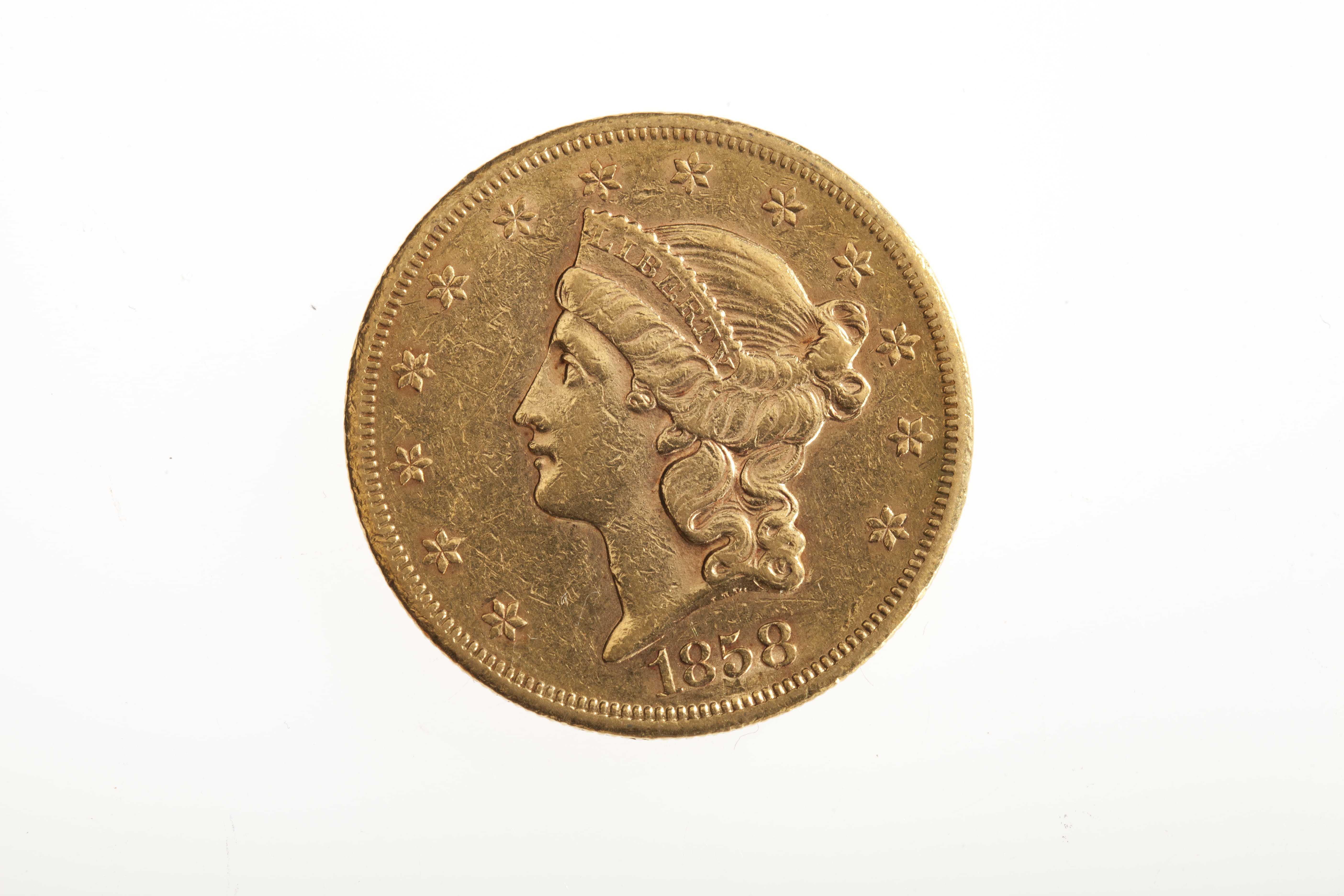 A gold coin dated 1858, depicting a crowned woman.